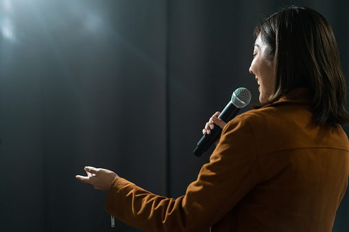 Close up woman hand holding High quality dynamic microphone and singing song or speaking talking with people on isolated white background. Woman testing microphone voice for interview