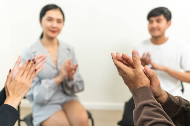 istock Applauding in group therapy session. Support of counselor diverse people friend group help motivation. Diverse young people in support friends sharing success story 1687782867