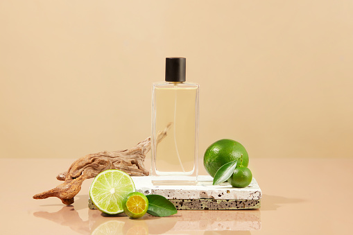 Spray bottle containing liquid placed on stone podium with kumquats and limes. The scent of Lime and Kumquat essential oil creates a feeling of comfort