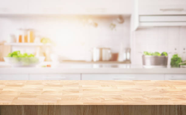 istock Selective focus.End grain wood counter table top on blur white cozy kitchen in morning background 1687897088