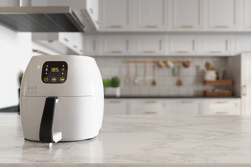 Close-up View Of Air Fryer On Kitchen Island With Blurred Background