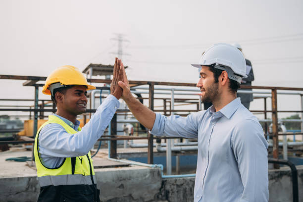 istock Success Stacked and Shake in a Hand. Professional Technician Ensuring Pollution Control in Wastewater Treatment Plant. Worker checking the waste water treatment pond industry. 1687899916