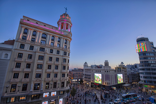 Gran Via street at blue hour, Madrid, Spain. Crowd of people at Callao Square.