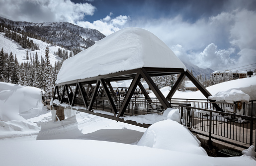 Mountain pedestrian bridge covered in snow after blizzard.