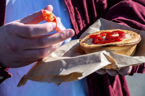 istock Man with pie and sauce, an Australian classic. 1687901860