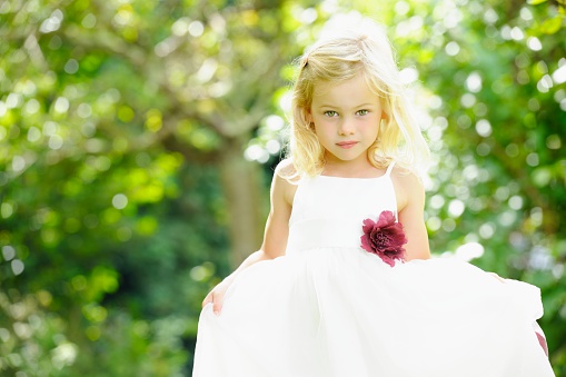 A portrait of a cute caucasian little girl/ bridesmaid/ flower girl in the garden.