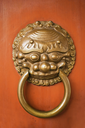 Ancient metal handle door knocker on old wooden doors background.Selective focus.