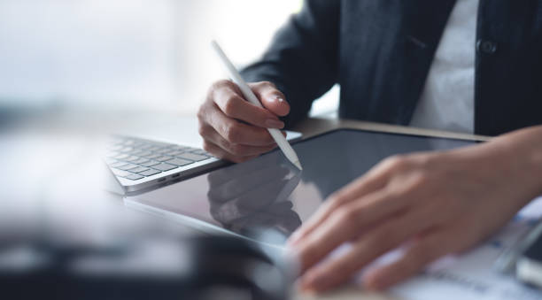 istock Businesswoman using stylus pen signing on digital tablet via mobile app, proofing e-document on office table. Business woman, project manager planning and working on computer, business technology 1687922377