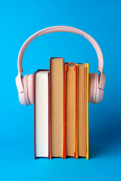 istock Pink headphones on stack of books against blue background 1687989583