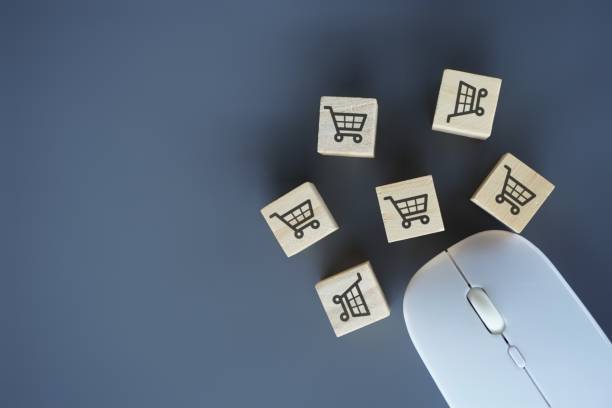 istock Computer mouse and wooden cubes with shopping trolley icon. 1687994395