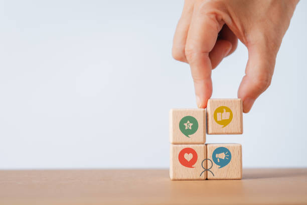 istock User-generated content concept.(UGC) Online marketing concept. Customer create content on social media . Close up hand put wooden cube with icon including copy space 1687996646