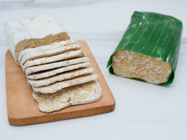 istock raw tempeh or tempe. tempeh slices on wooden cutting board. Tempeh is made from fermented soybeans 1688002000