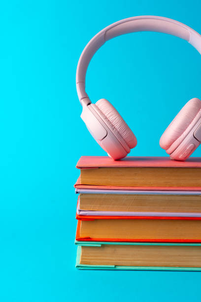 istock Pink headphones on a book on blue background 1688002010