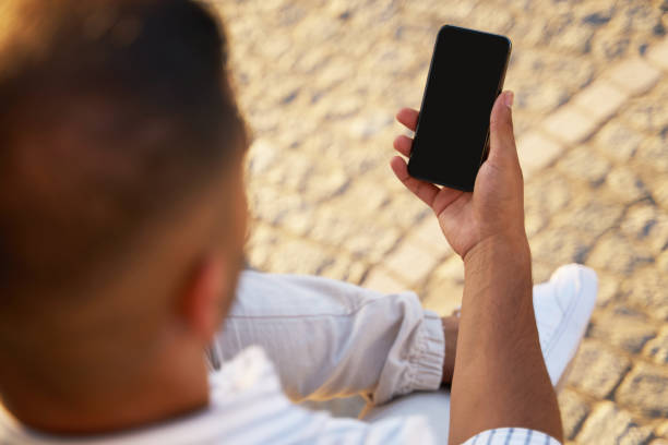 istock Man holding smartphone using mobile app shopping online on the street. E-commerce concept 1688007546