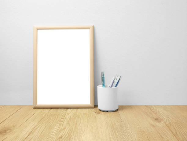 istock Blank frames mockup on wooden floor with pen 1688027438
