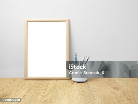 istock Blank frames mockup on wooden floor with pen 1688027438
