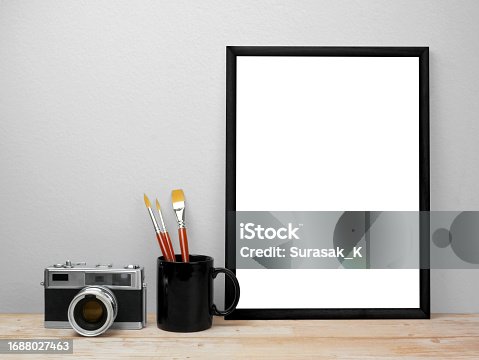 istock Blank frames mockup on wooden floor with camera and paintbrush 1688027463