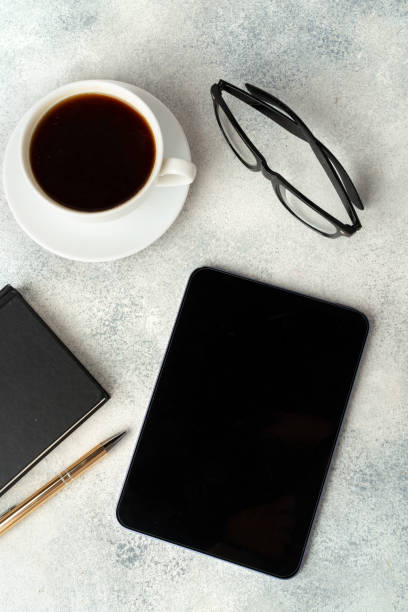 istock E-book reader, cup of coffee and glasses on gray surface 1688032541