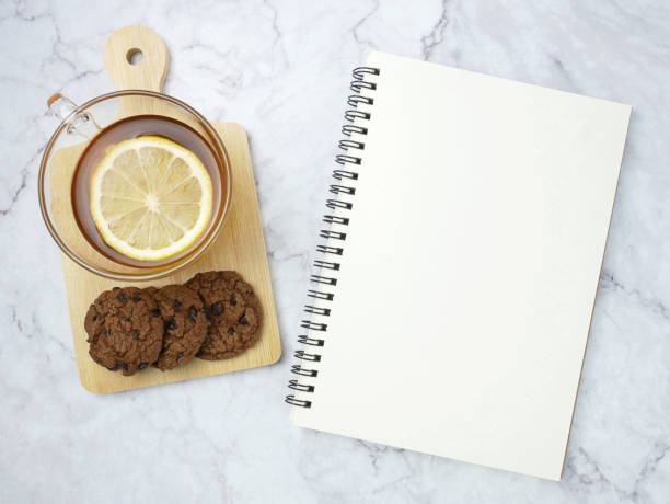 istock Lemon tea and book on marble texture background. 1688055484