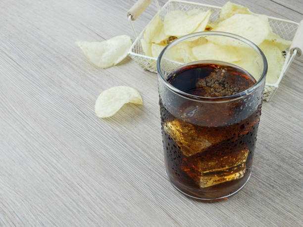 istock Soft drink and potato chips on wooden background. 1688056582