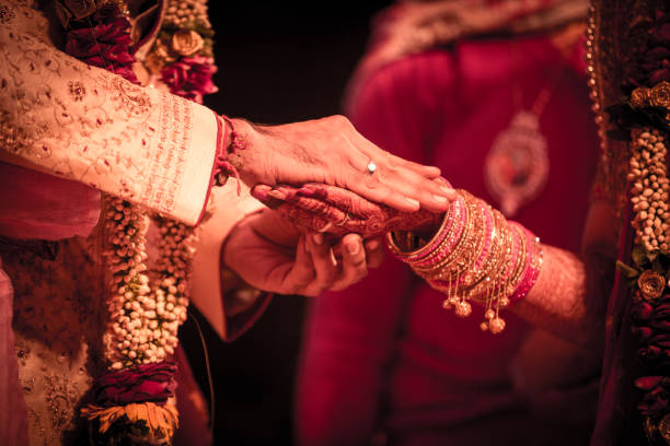 primer plano de una pareja de bodas india tomados de la mano. - men groom wedding red fotografías e imágenes de stock