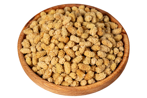 Dried mulberries in wooden bowl. Sun-dried mulberry isolated on white background.