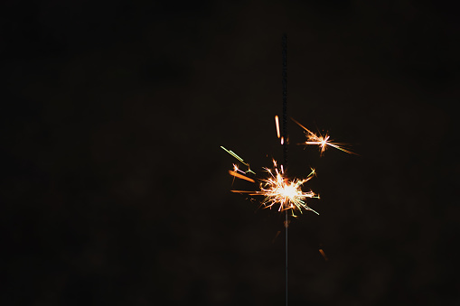 photography, sparkler close-up on a dark background, holiday lights