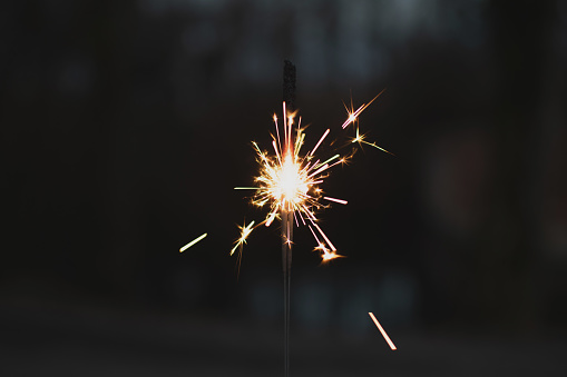 photography, sparkler close-up on a dark background, holiday lights