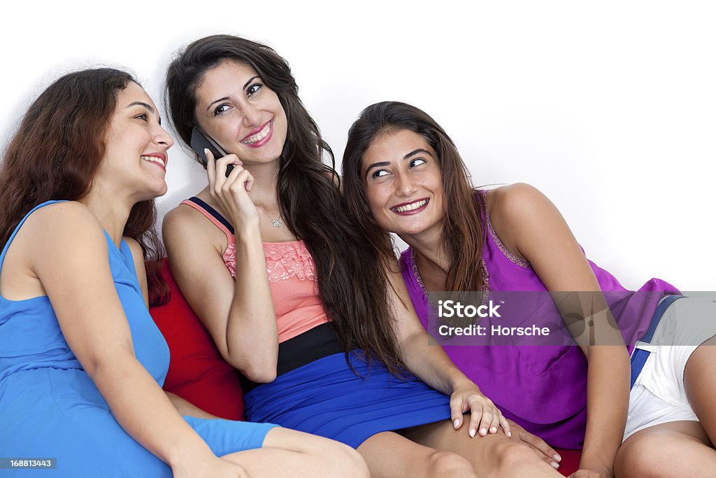 Trzy piękne młode kobiety za pomocą inteligentnego telefonu komórkowego. - Zbiór zdjęć royalty-free (Biały)