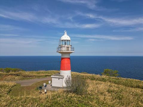 high lighthouse on a sandy shore full of dunes