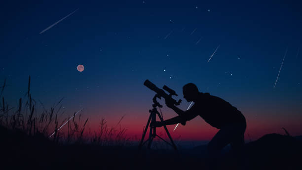 istock Astronomer looking at the stars, planets, Moon and celestial objects with a telescope. 1688142312