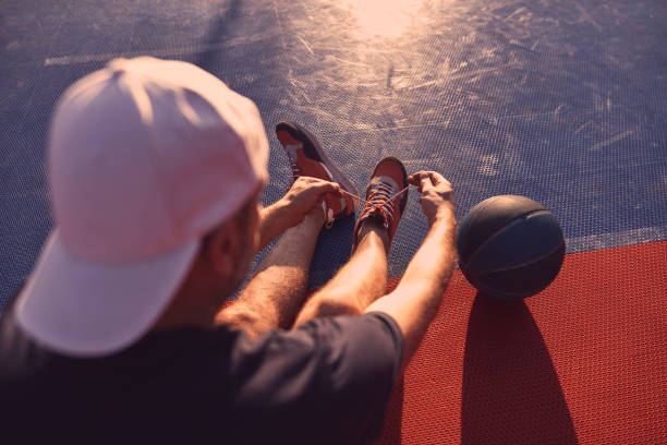 istock Man making pause after playing basketball on a open public court. 1688149478