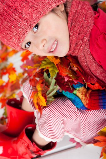 Happy 8 year old white girl sitting on autumn doorstep