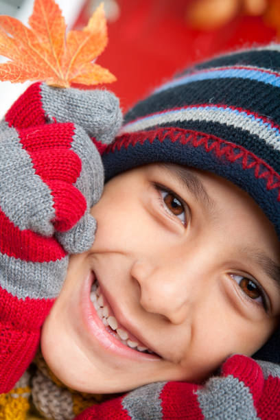 Close up Smiling white boy warm fall clothing sitting at front entrance