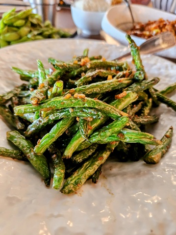 Close-up for wok fried string beans on a plate.