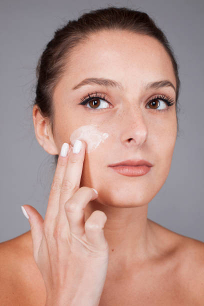 istock Delighted female with radiant skin applying cream 1688230042