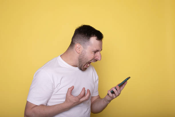istock Angry man talk on smartphone isolated on yellow. 1688238679