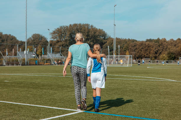 Mother and daughter going to football stock photo
