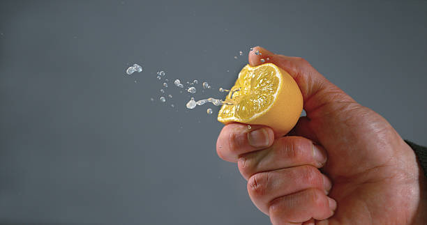 istock Hand of Man Squeezing Lemon, citrus limonum against Black Background 1688255250