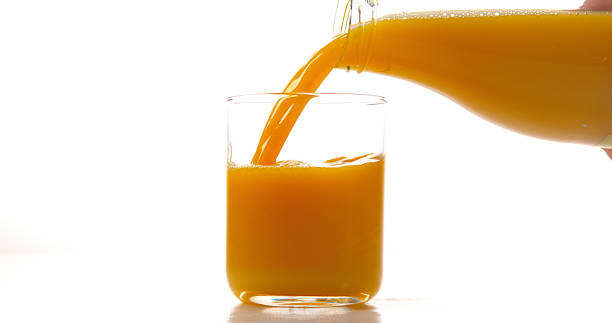 istock Orange Juice being poured into Glass against White Background 1688258051