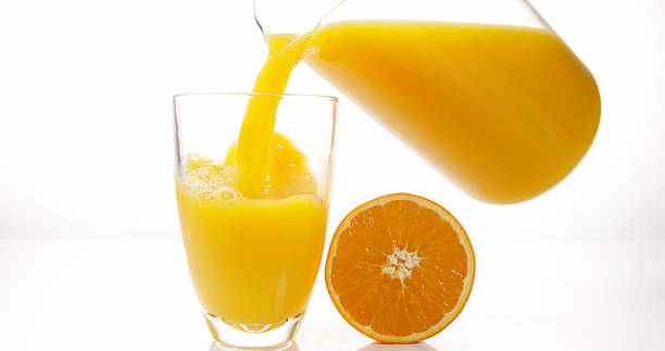 istock Orange Juice being poured into Glass against White Background 1688259235
