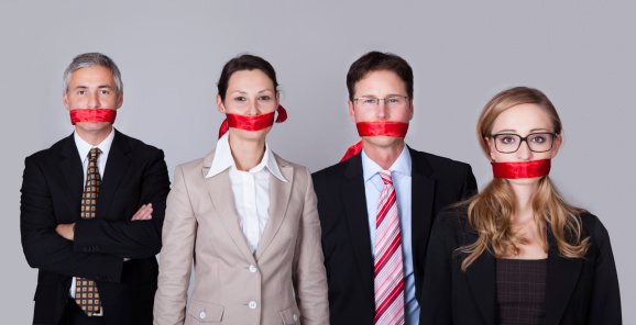 Businesspeople bound by red tape around their mouths standing in a row unable to speak or divulge information