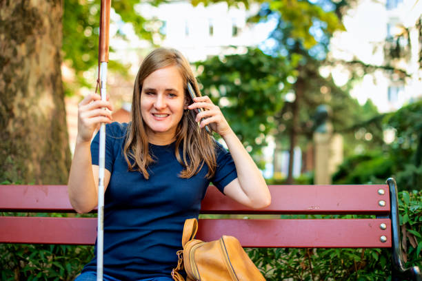 istock A visually impaired woman holding a white cane and having a call outside 1688270214