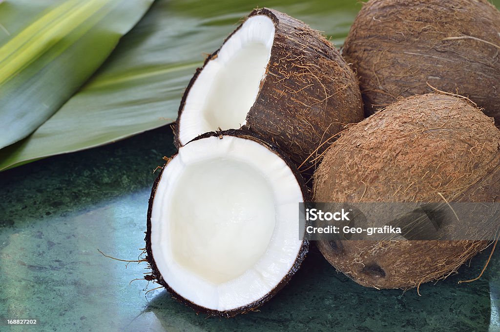 Alcune noci di cocco su lastra in marmo verde - Foto stock royalty-free di Acqua di cocco