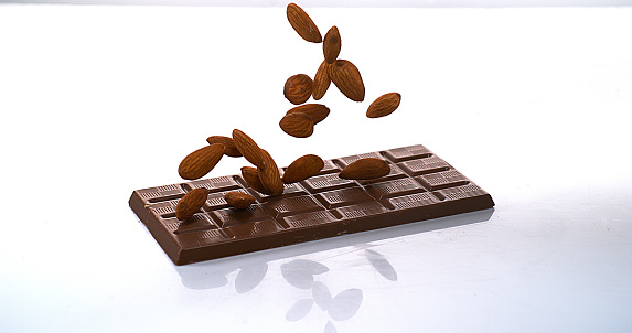 Almonds falling on Milk Chocolate tablet