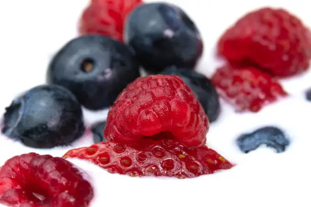 Photo of Close-up of a bowl with natural white yogurt and fresh raspberries, blueberries, strawberries, macro photography. Delicious healthy breakfast