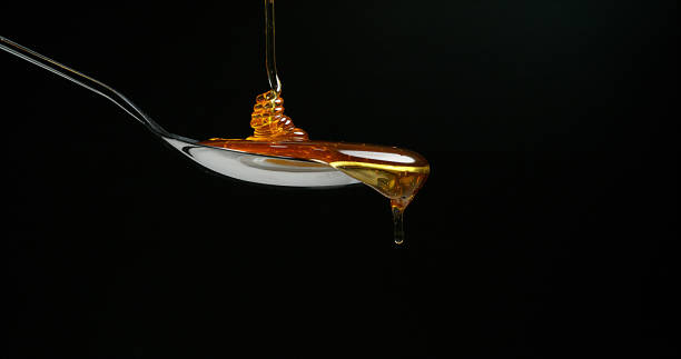 istock Honey Flowing against Black Background 1688294066
