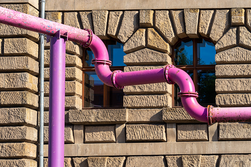 Germany, Berlin, August 13, 2023 -Pink water pipe against building in city, Berlin Central