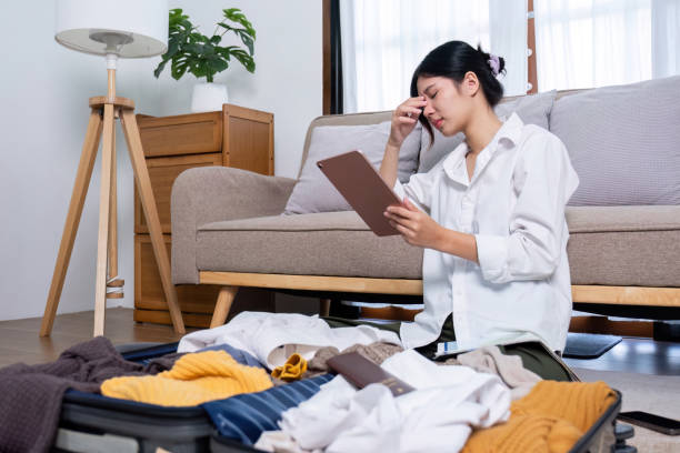 A young female tourist was disappointed after her trip was canceled while she was preparing her things.