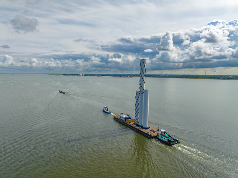 Wind turbine components transported by ship to a construction site in an offshore wind farm in a new wind park in the IJsselmeer in Flevoland, Netherlands.